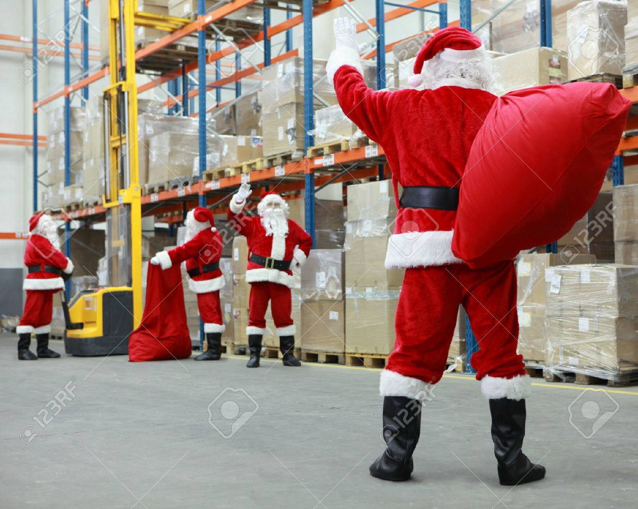 Group of santa clauses working together in storehouse with gifts - 33313525 Group of santa clauses working together in storehouse with gifts - 33313525
