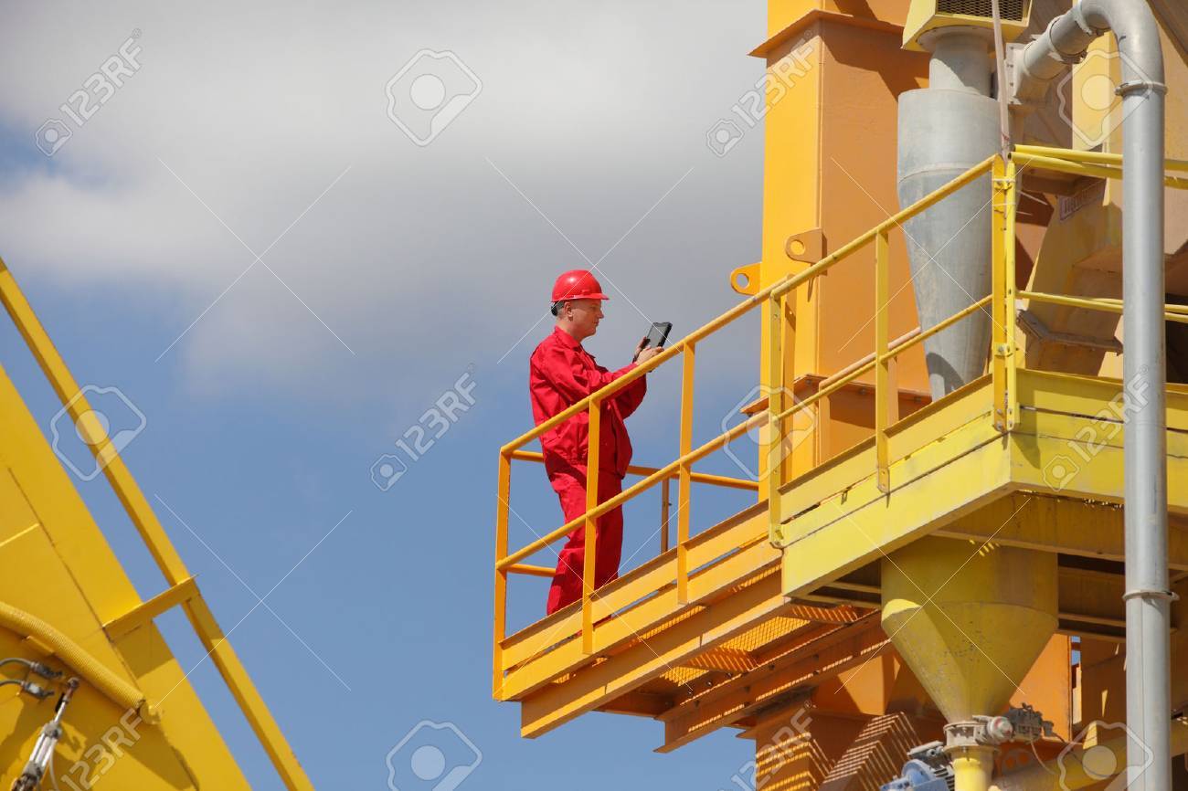 worker in red uniform and hard hat checking data on tablet on large industrial platform - 35709973 worker in red uniform and hard hat checking data on tablet on large industrial platform - 35709973