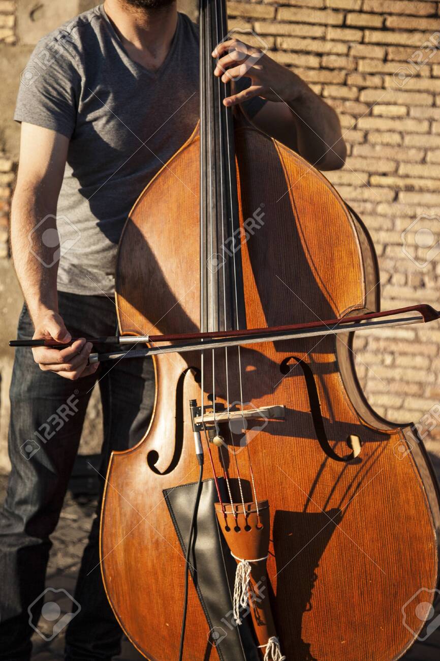 Musician playing the cello outside in a sunny day - 146507435 Musician playing the cello outside in a sunny day - 146507435
