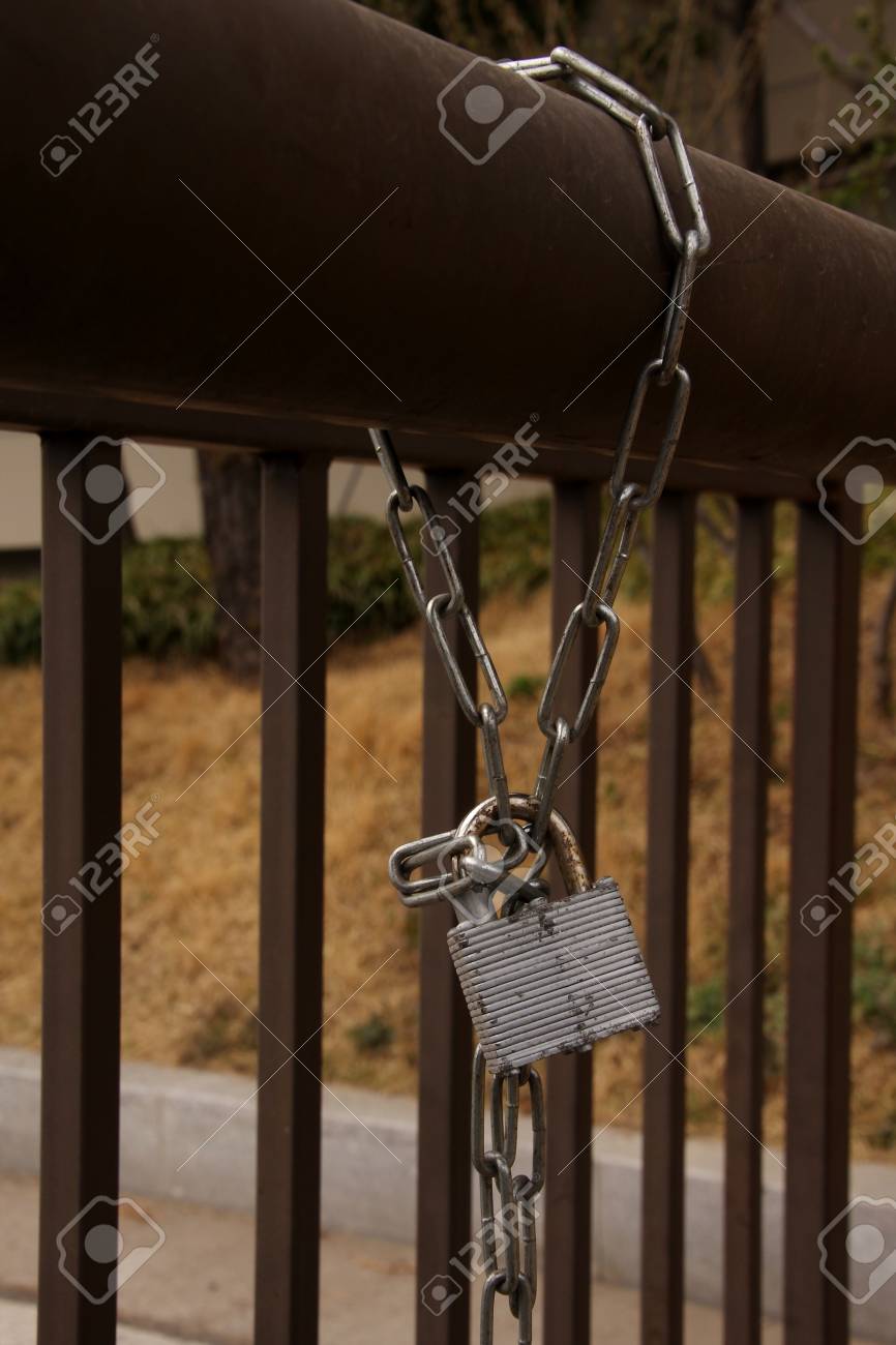 Ein Metallschloss Vorhängeschloss Und Kette Auf Zaun In Einem Garten ... Ein Metallschloss Vorhängeschloss Und Kette Auf Zaun In Einem Garten ...