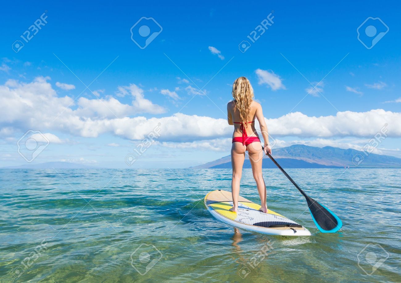 attractive woman on stand up paddle board sup tropical blue blue ocean