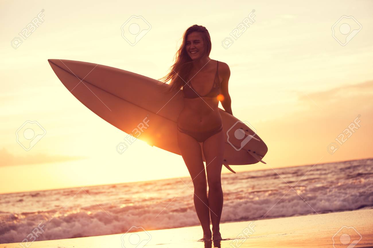 夕暮れ時のビーチの美しいサーファーガールのシルエット の写真素材 画像素材 Image