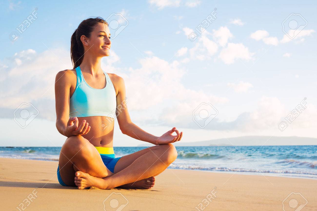 Jeune Femme à Pratiquer Le Yoga Sur La Plage Au Coucher Du Soleil