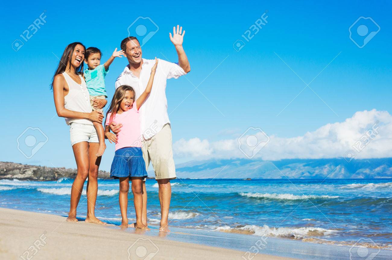 Happy Mixed Race Family of Four Playing on the Beach - 32218569 Happy Mixed Race Family of Four Playing on the Beach - 32218569