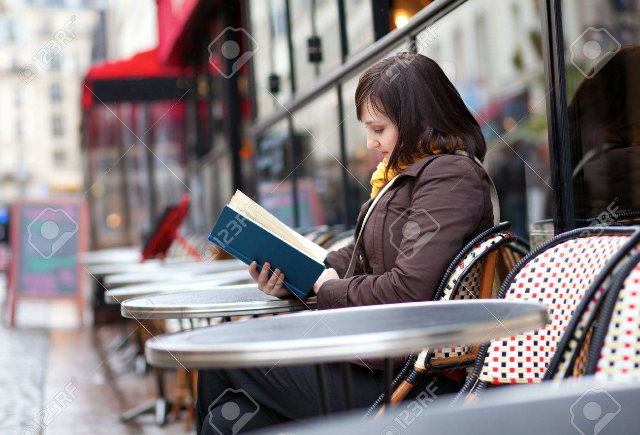 パリの通りのカフェで本を読んで美しい若い女の子 の写真素材 画像素材 Image