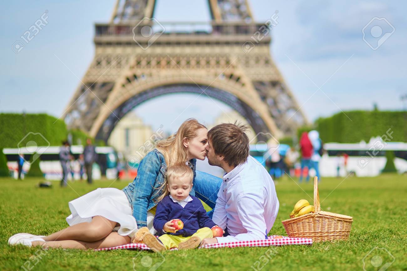 3 つの幸せな家族は 母と父とパリでピクニックを持つ幼児男の子エッフェル塔を周辺します の写真素材 画像素材 Image