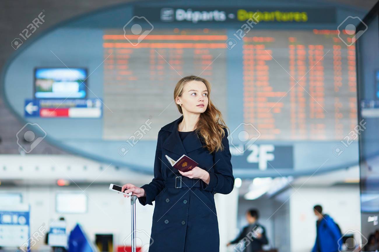彼女の手でフランスのパスポートを保持している国際空港フライト情報ボードの若い女性 の写真素材 画像素材 Image 彼女の手でフランスのパスポートを保持している国際空港フライト情報ボードの若い女性 の写真素材 画像素材 Image