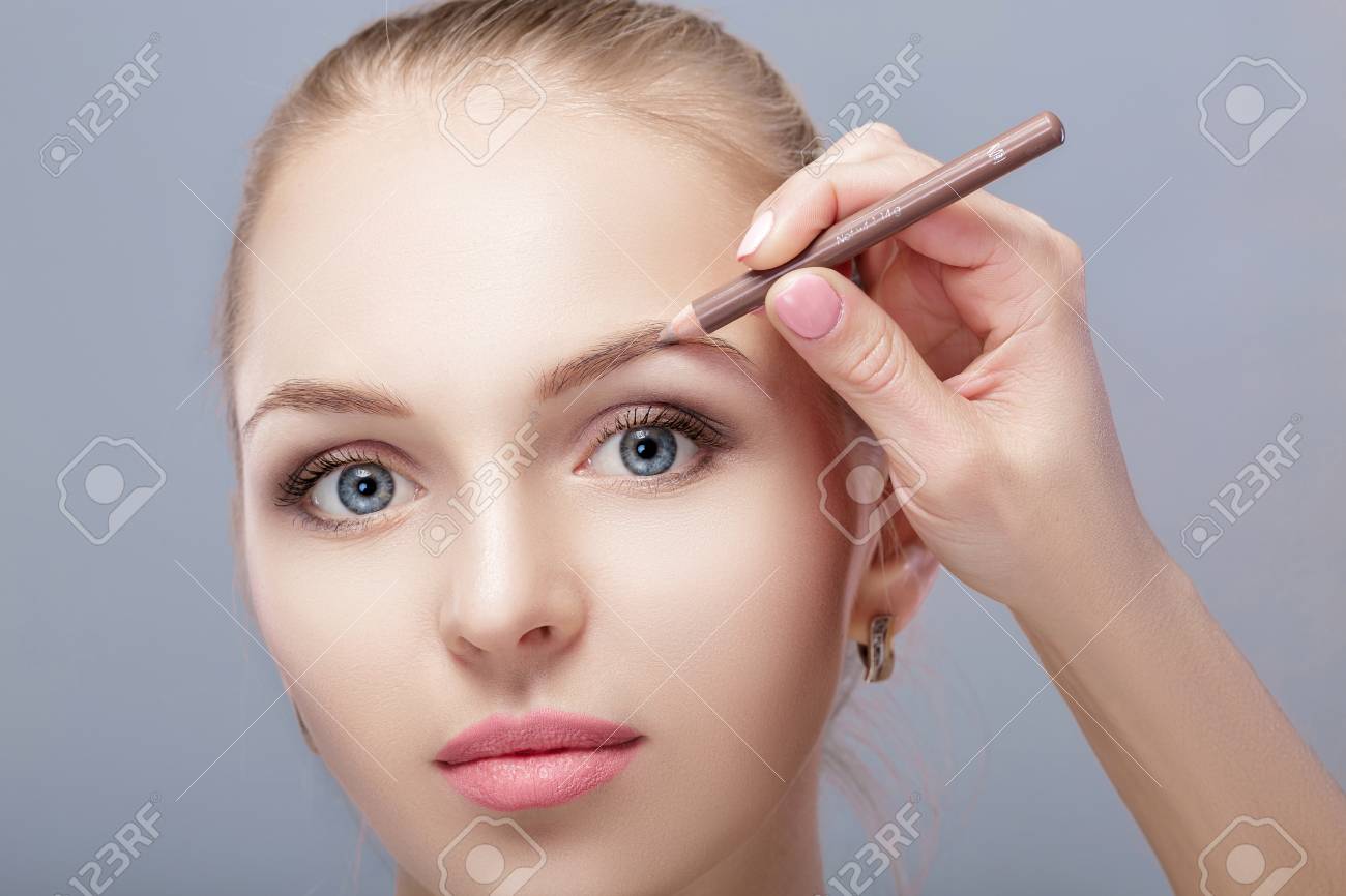 金髪の美しい女性は 眉メイクのプロな鉛筆を使用します の写真素材 画像素材 Image