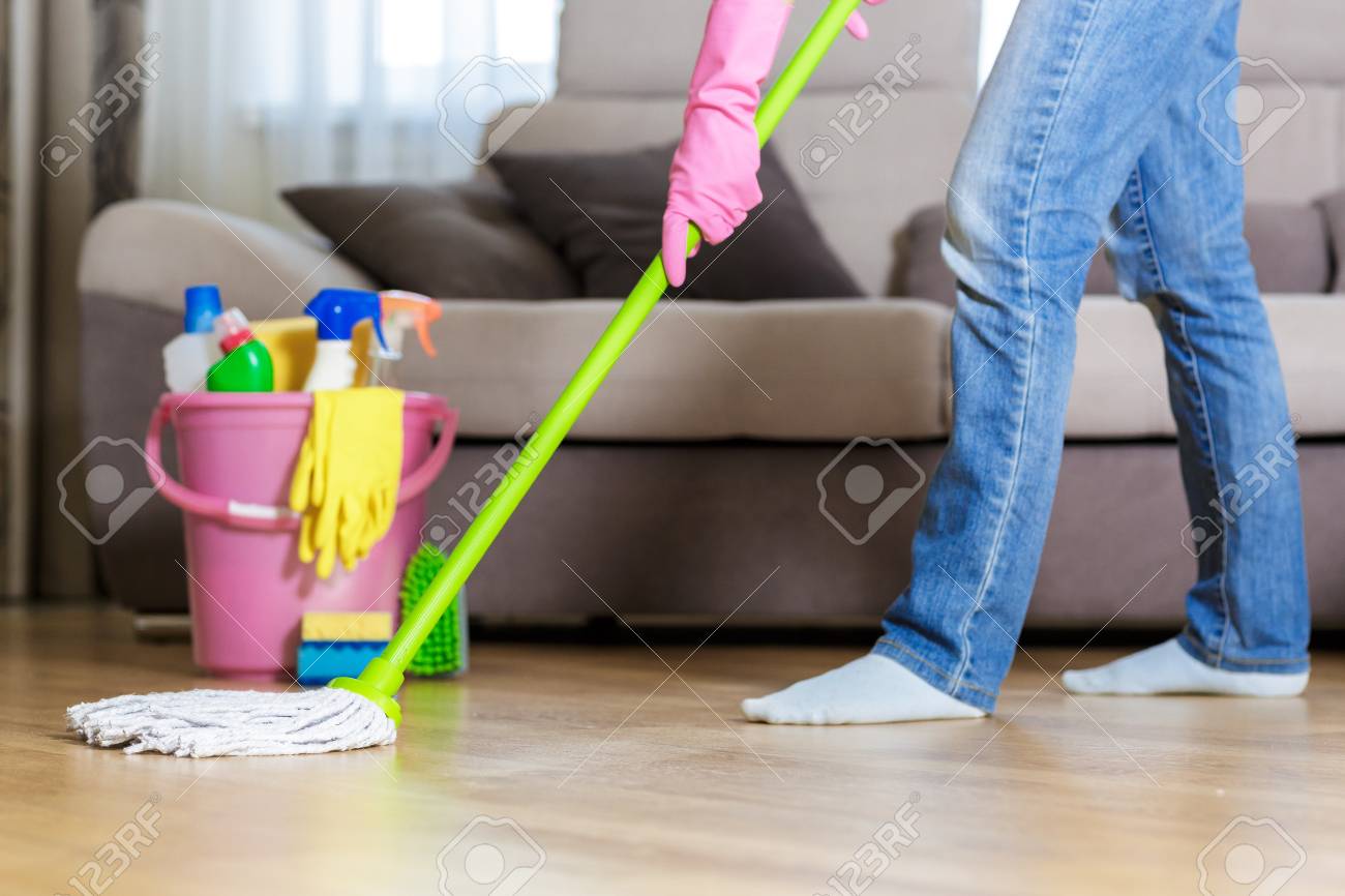 Woman In Protective Gloves Using A Wet Mop While Cleaning Floor