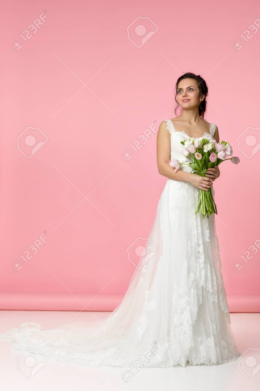 Beautiful Bride With Wedding Bouquet Of Pink Tulips On Pink