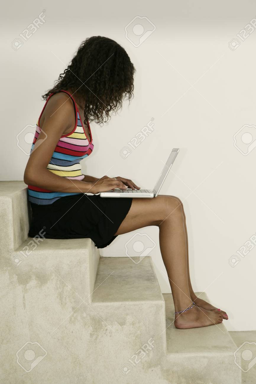 Female sitting on stairs and working on laptpo - 7597332 Female sitting on stairs and working on laptpo - 7597332
