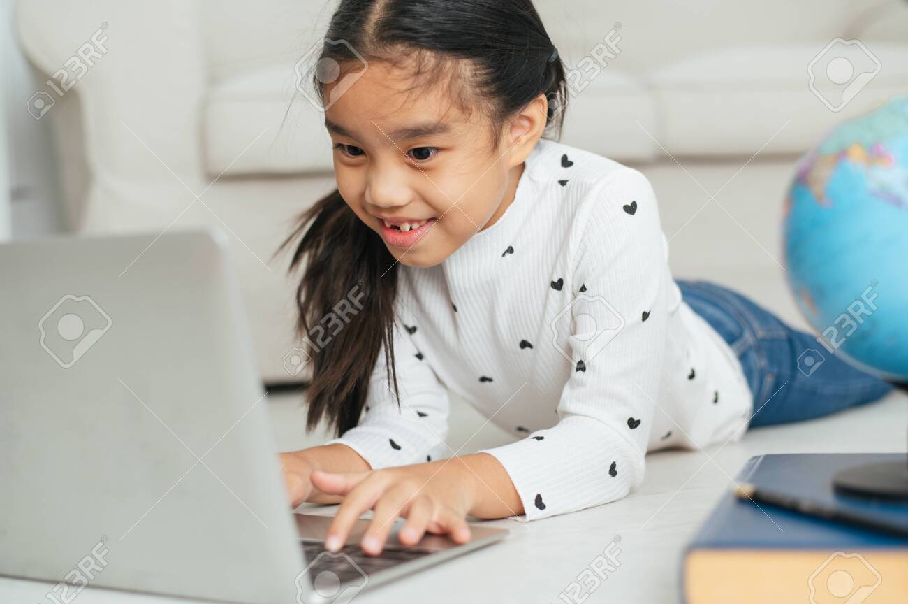 Happy Asian girl using laptop computer, concept for kid's art and home school. - 130115658 Happy Asian girl using laptop computer, concept for kid's art and home school. - 130115658