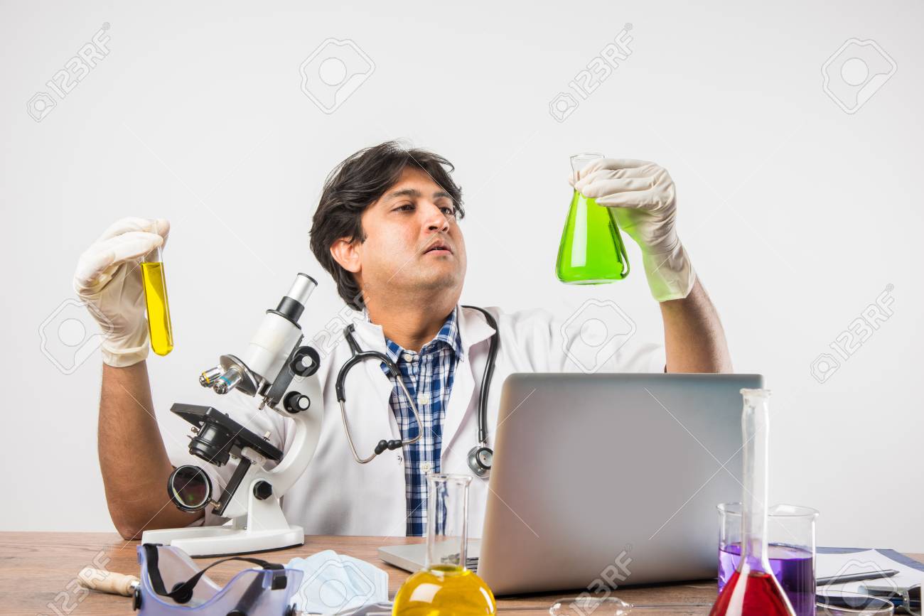 Asian Indian Male Scientist Or Doctor Or Science Student Experimenting With Microscope And Chemicals Asian Indian Male Scientist Or Doctor Or Science Student Experimenting With Microscope And Chemicals