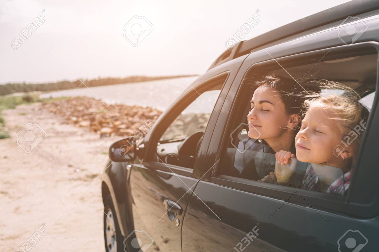 Happy family on a road trip in their car. Dad, mom and daughter are traveling by the sea or the ocean or the river. Summer ride by automobile. - 119521380 Happy family on a road trip in their car. Dad, mom and daughter are traveling by the sea or the ocean or the river. Summer ride by automobile. - 119521380