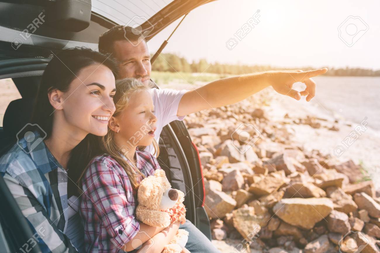 Happy family on a road trip in their car. Dad, mom and daughter are traveling by the sea or the ocean or the river. Summer ride by automobile - 119511805 Happy family on a road trip in their car. Dad, mom and daughter are traveling by the sea or the ocean or the river. Summer ride by automobile - 119511805
