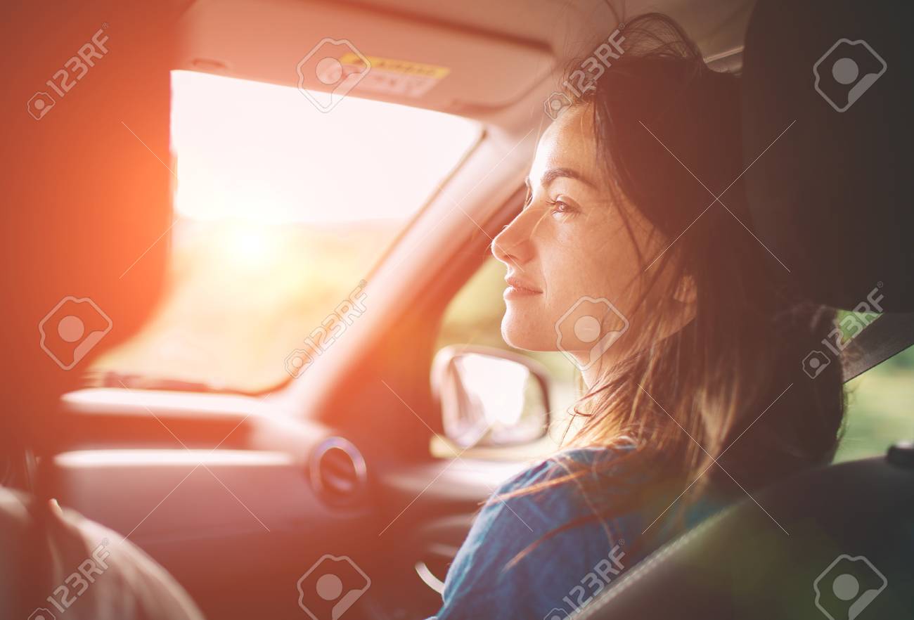 Beautiful woman smiling while sitting on the front passenger seats in the car - 92909340 Beautiful woman smiling while sitting on the front passenger seats in the car - 92909340