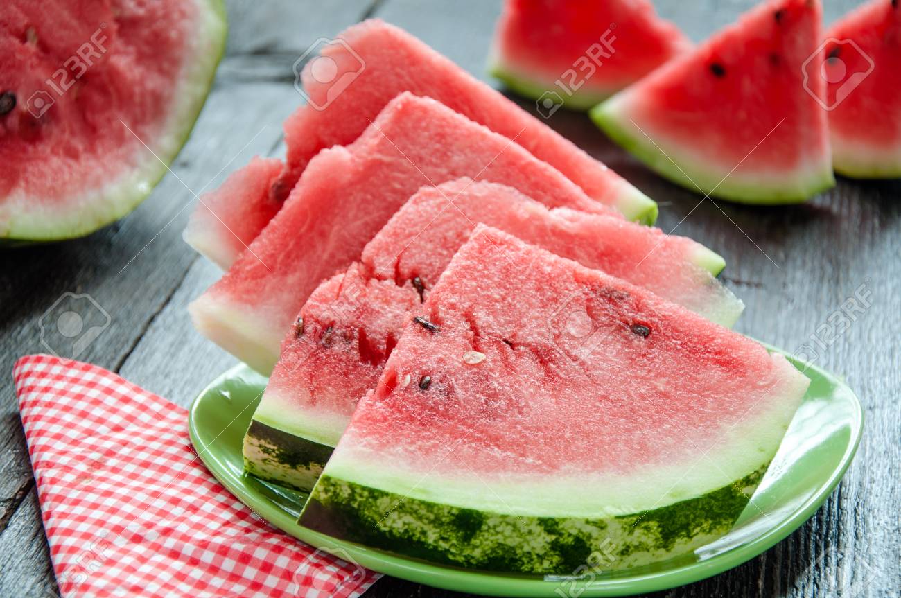 Ripe watermelons on table on wooden background - 34194757 Ripe watermelons on table on wooden background - 34194757
