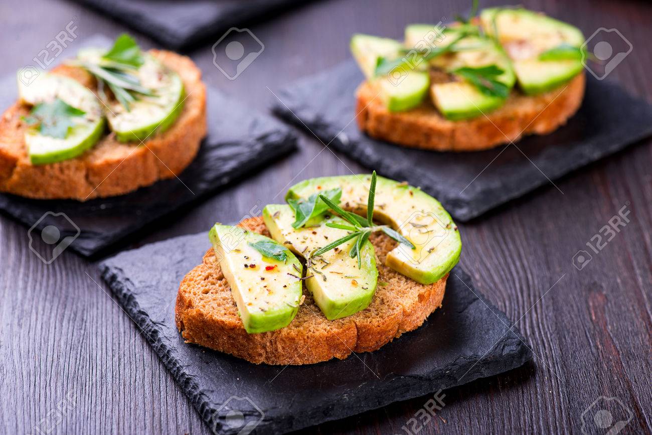 Toast with rye bread and avocado, herbs on slate board - 58050393 Toast with rye bread and avocado, herbs on slate board - 58050393