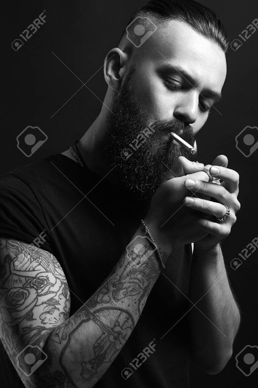 Handsome Brutal Bearded Smoking Man. Hipster Tattoed Boy With Cigarette  Stock Photo, Picture And Royalty Free Image. Image 139557868.