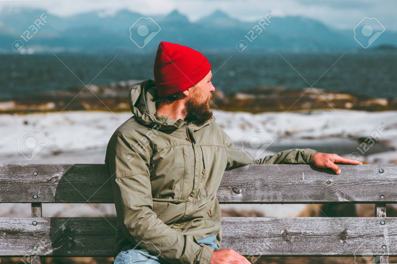 男は海と山の風景ノルウェー休暇旅行ライフ スタイル コンセプトを楽しむベンチでリラックス 旅行者だけを着て座っているファッションの赤い帽子は 秋の季節を考えて の写真素材 画像素材 Image 9864
