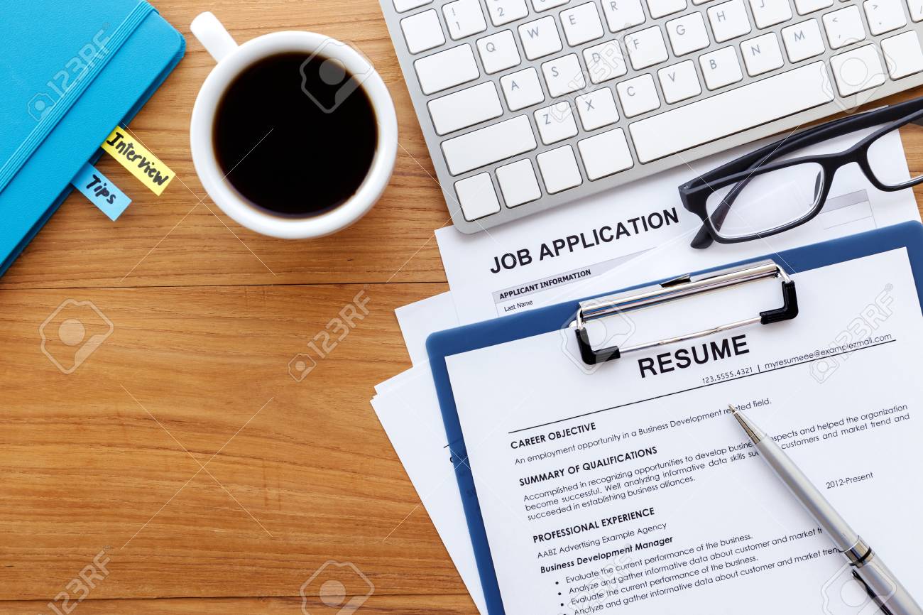 resume and job application on wood desk background for job search career background summary