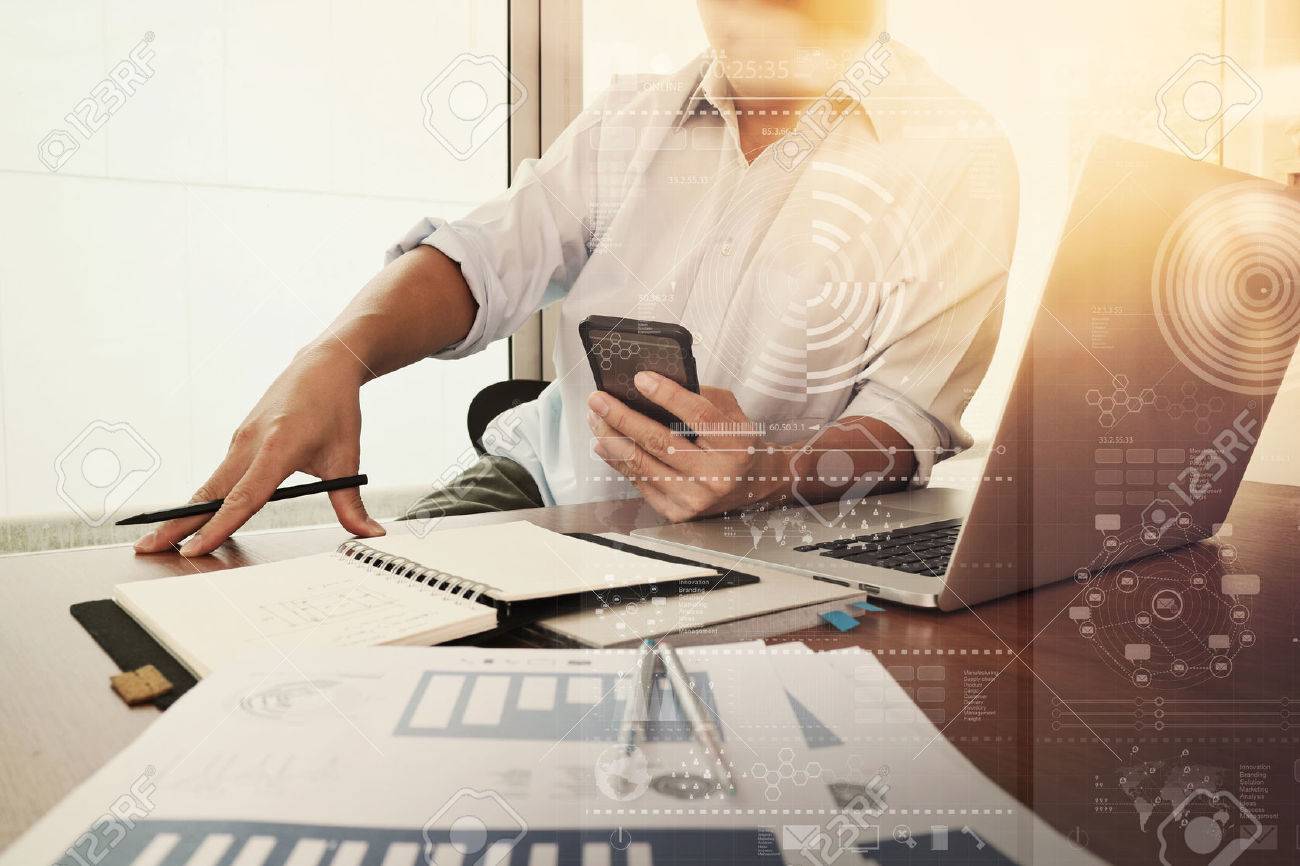 business documents on office table with smart phone and laptop computer and graph business diagram and man working in the background - 50068968 business documents on office table with smart phone and laptop computer and graph business diagram and man working in the background - 50068968