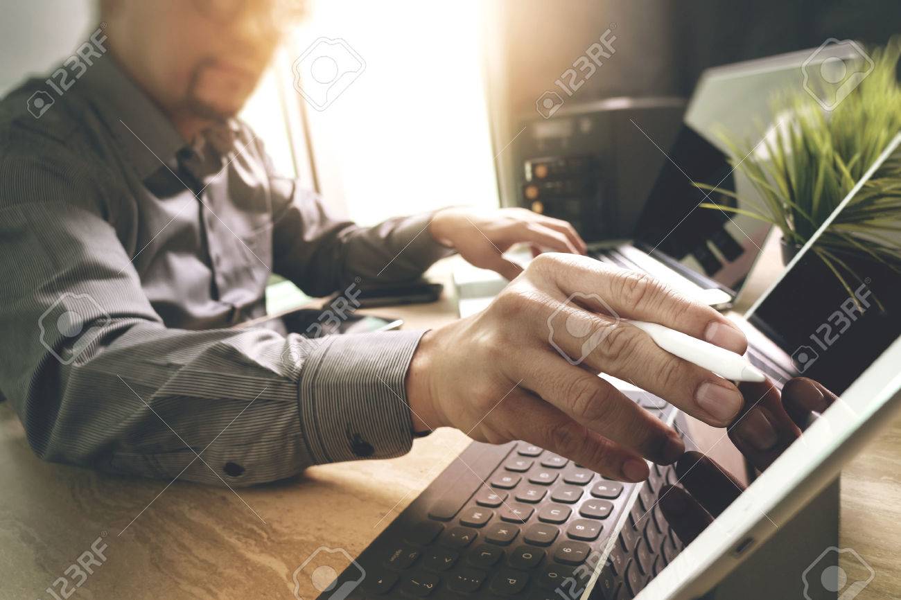 Outsource Developer working on marble Desk Working Laptop Computer Mobile Application Software and digital tablet dock smart keyboard,compact server,sun flare effect - 64119124 Outsource Developer working on marble Desk Working Laptop Computer Mobile Application Software and digital tablet dock smart keyboard,compact server,sun flare effect - 64119124