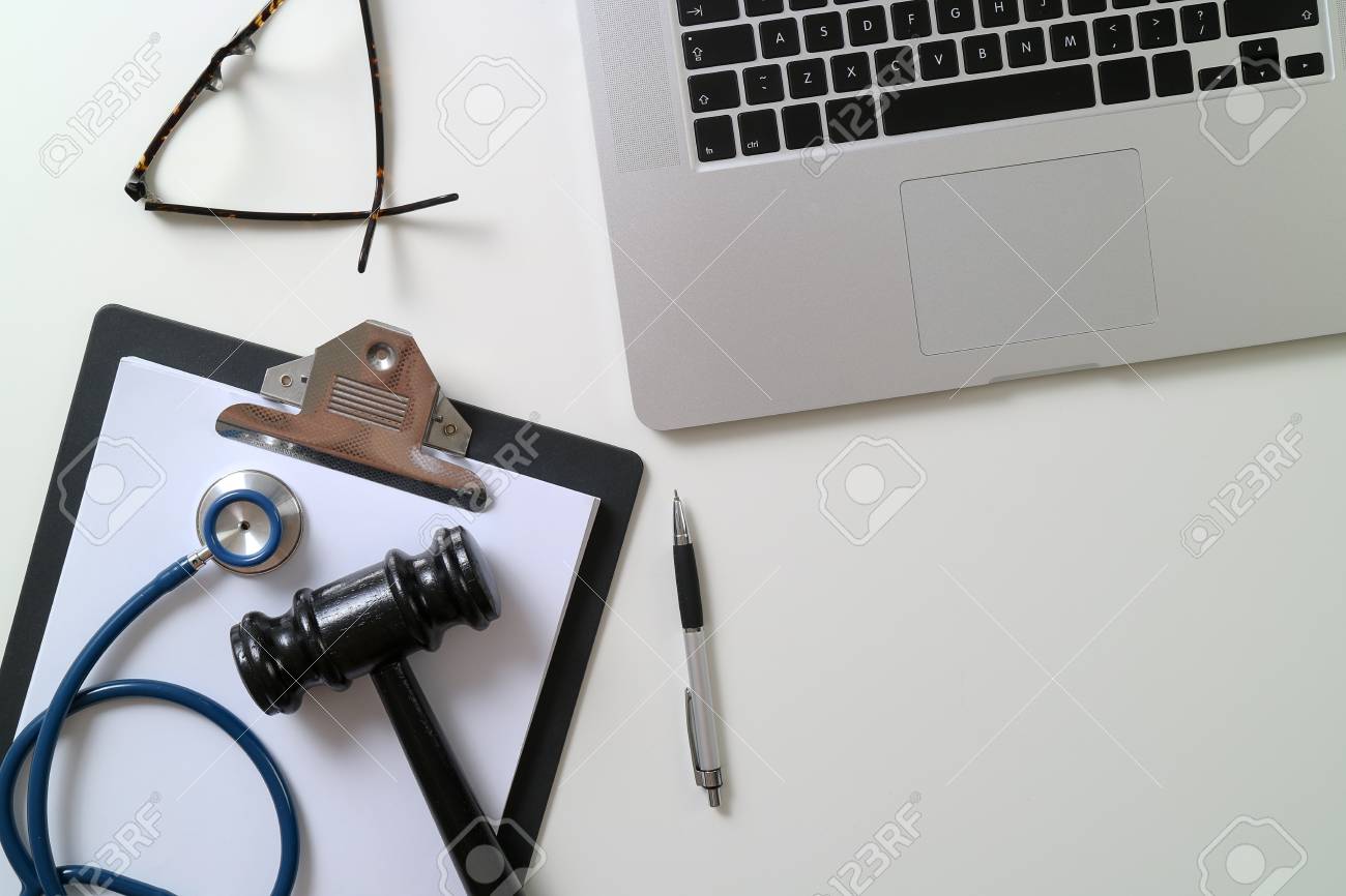 Dark Gavel With Medical Stethoscope near Laptop on white desk In Courtroom concept - 88997772 Dark Gavel With Medical Stethoscope near Laptop on white desk In Courtroom concept - 88997772