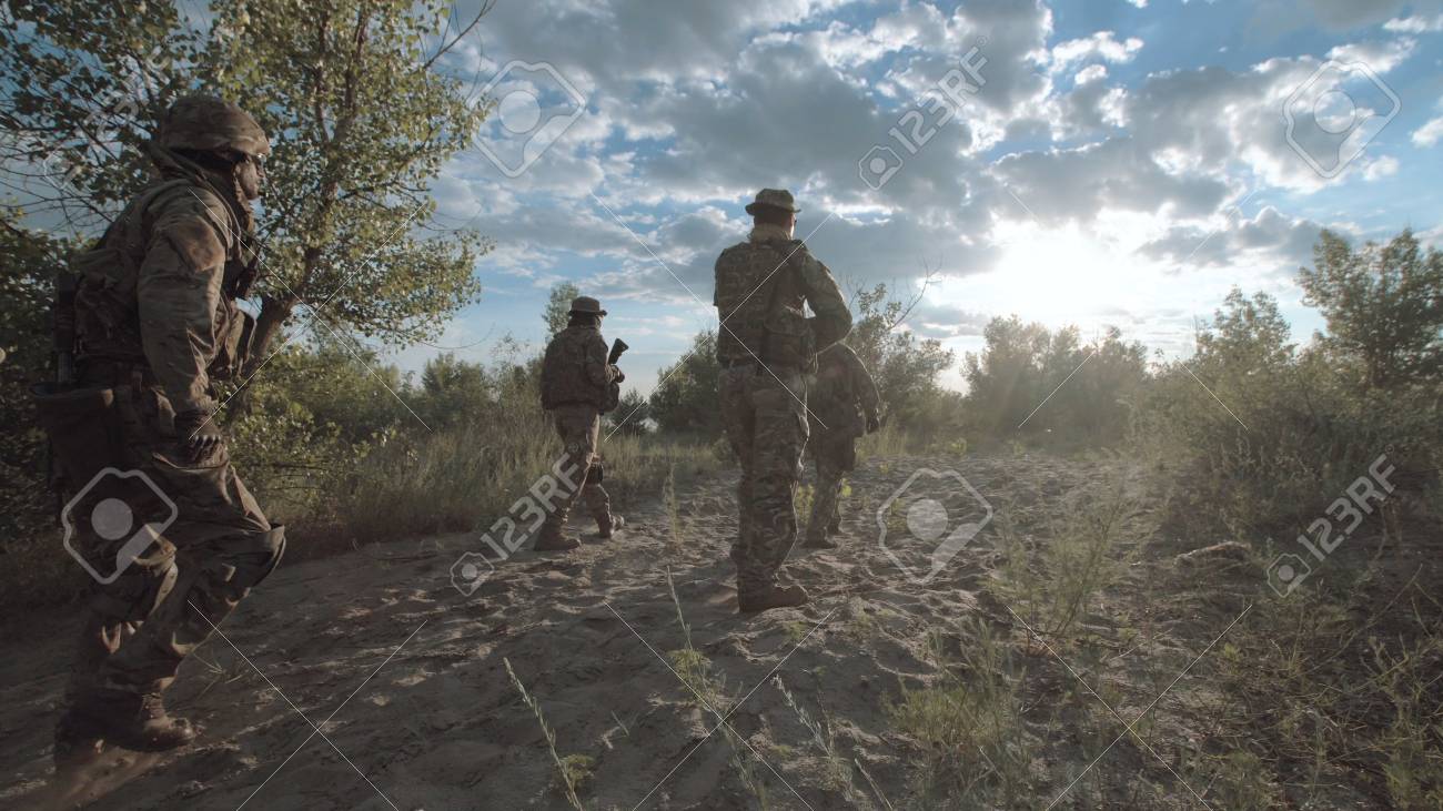機器と共に戦場の上を歩く兵士のグループの背面図 の写真素材 画像素材 Image