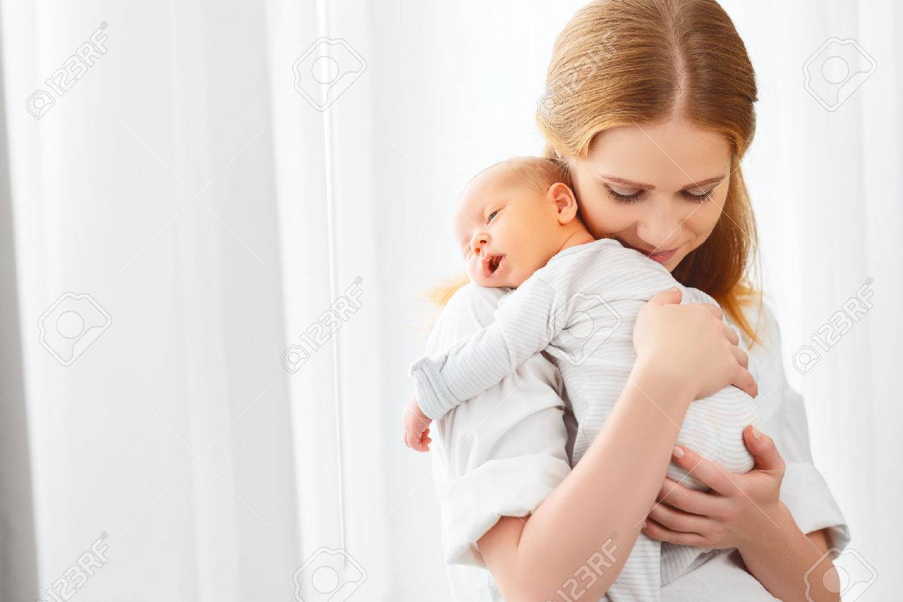 newborn baby in a tender embrace of mother at the window - 55011053 newborn baby in a tender embrace of mother at the window - 55011053