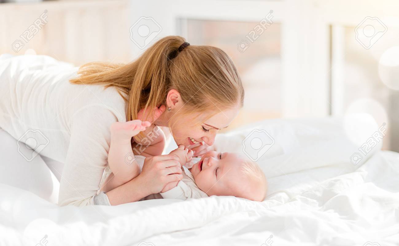 happy family mother in bed with newborn baby - 57753594 happy family mother in bed with newborn baby - 57753594