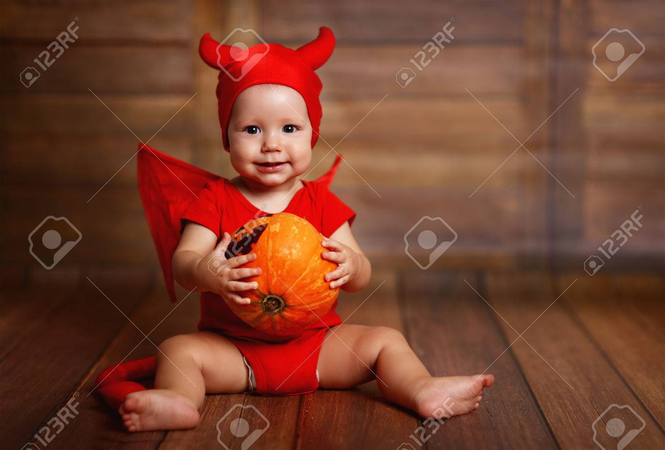 Funny Baby In Devil Halloween Costume With Pumpkin On A Dark Wooden Background Stock Photo Picture And Royalty Free Image Image