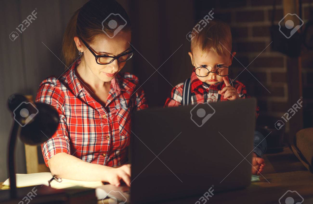 woman mother working with a baby at home behind a computer via the Internet - 70185455 woman mother working with a baby at home behind a computer via the Internet - 70185455