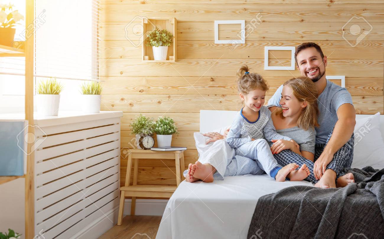 happy family mother, father and child daughter laughs in bed - 86175475 happy family mother, father and child daughter laughs in bed - 86175475