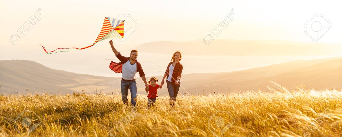 Happy family father, mother and child daughter launch a kite on nature at sunset - 97757776 Happy family father, mother and child daughter launch a kite on nature at sunset - 97757776