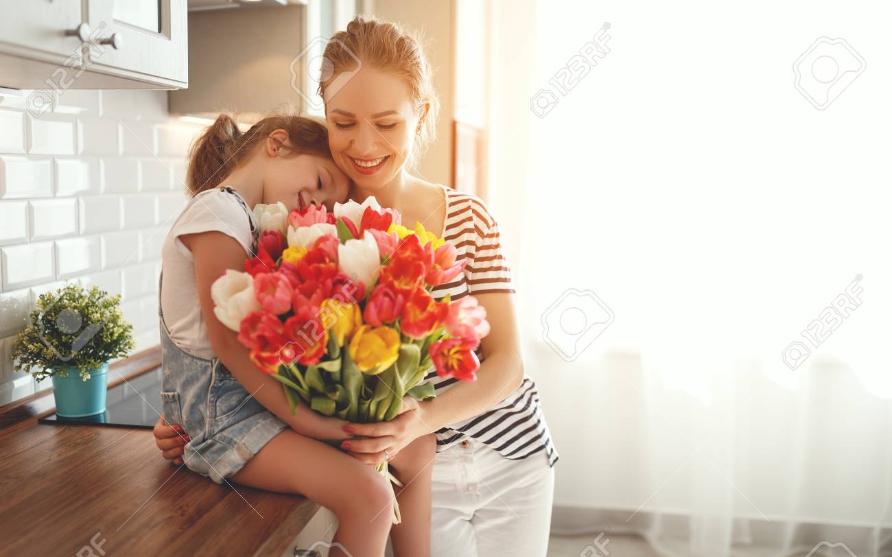 happy mother's day! child daughter congratulates mother and gives a bouquet of flowers to tulips - 97650064 happy mother's day! child daughter congratulates mother and gives a bouquet of flowers to tulips - 97650064