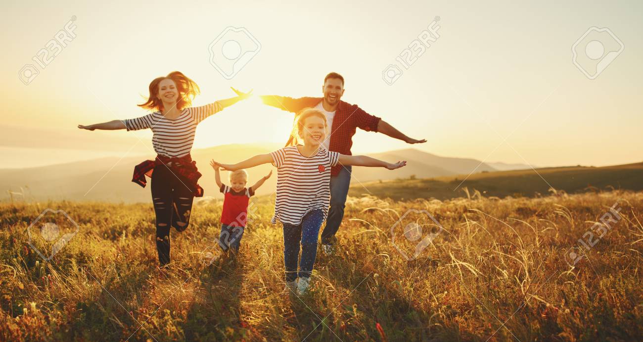 Happy family: mother, father, children son and daughter on nature on sunset - 105557667 Happy family: mother, father, children son and daughter on nature on sunset - 105557667