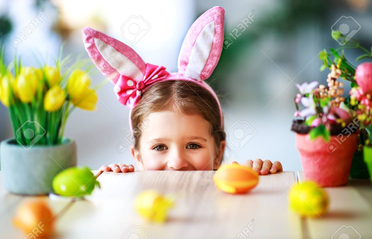 Happy easter! funny child girl with rabbit ears and eggs at home in kitchen - 116644152 Happy easter! funny child girl with rabbit ears and eggs at home in kitchen - 116644152