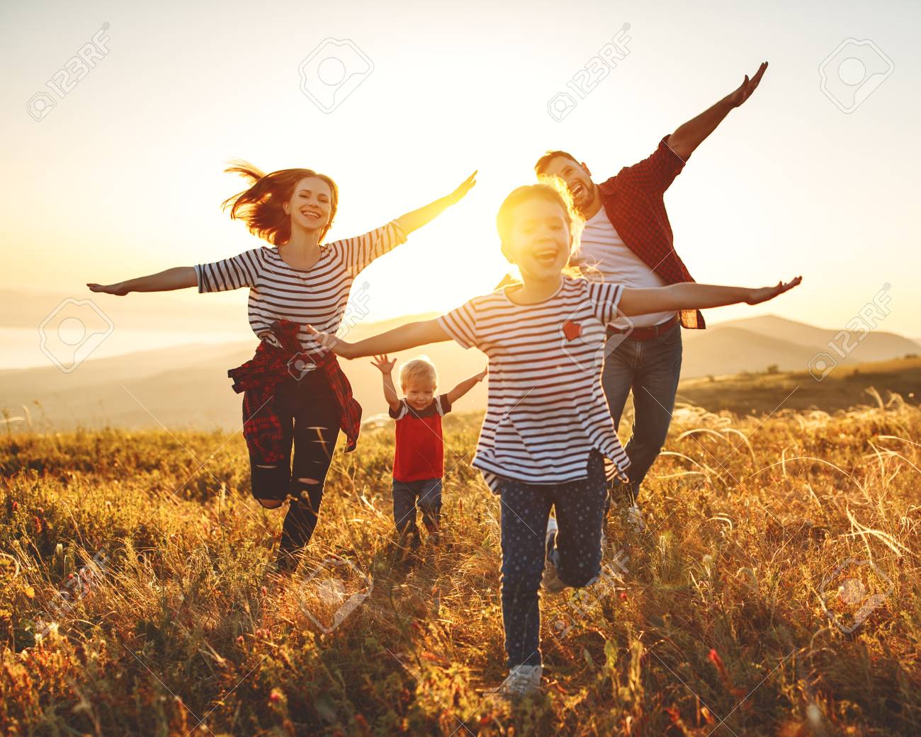 Happy family: Mother, father, children son and daughter on nature on sunset - 120402746 Happy family: Mother, father, children son and daughter on nature on sunset - 120402746