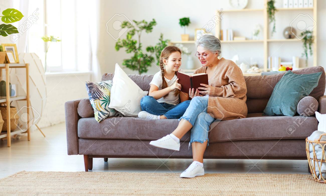 Happy family grandmother reading to granddaughter child book at home - 120628962 Happy family grandmother reading to granddaughter child book at home - 120628962