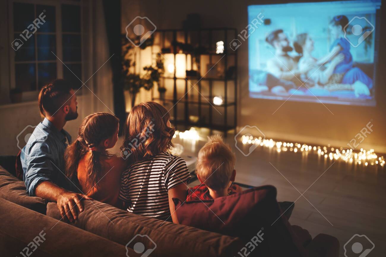 family mother father and children watching projector, TV, movies with popcorn in the evening at home - 130187064 family mother father and children watching projector, TV, movies with popcorn in the evening at home - 130187064