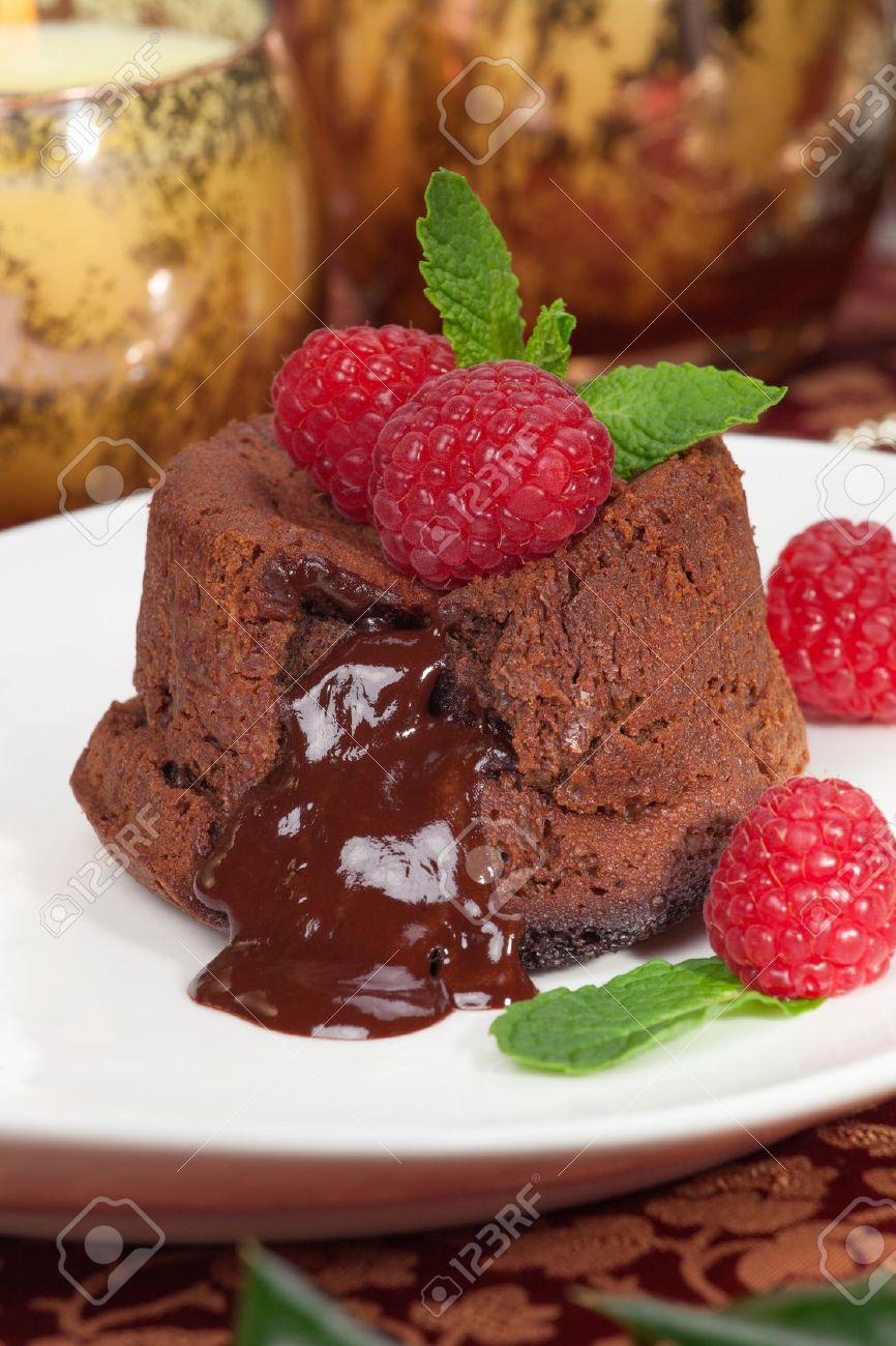 Delicious dark chocolate lava cake dessert served with fresh raspberries and mint Surrounded by Christmas ornaments - 17439452 Delicious dark chocolate lava cake dessert served with fresh raspberries and mint Surrounded by Christmas ornaments - 17439452