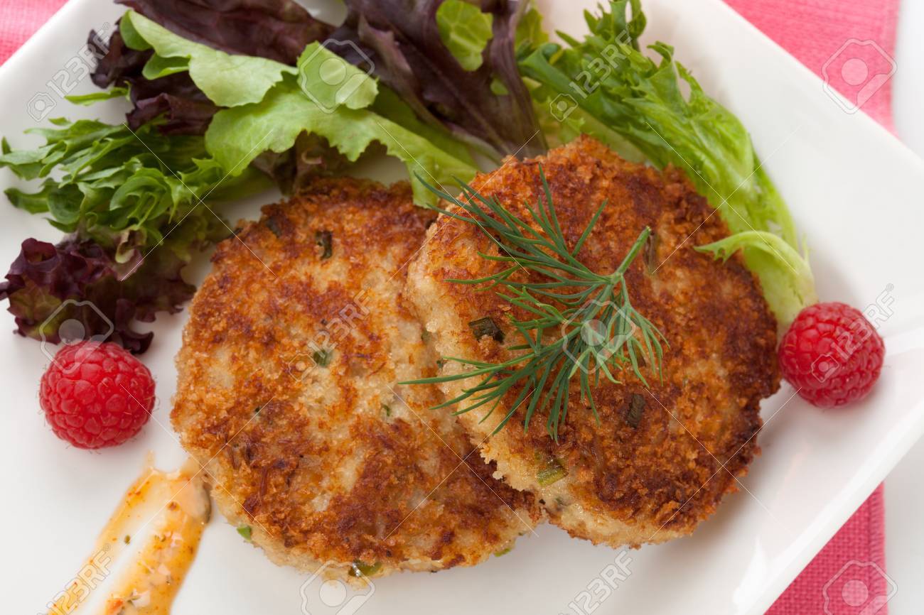 Two crab cakes appetizer garnished with spicy sauce, green salad, and raspbery - 22659382 Two crab cakes appetizer garnished with spicy sauce, green salad, and raspbery - 22659382