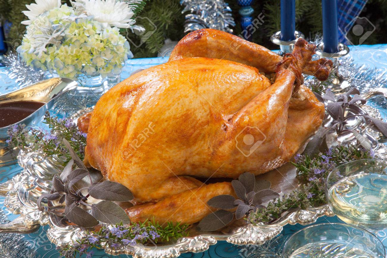 Roasted turkey garnished with herbs on blue Christmas decorations, and champagne Christmas tree as background - 22659359 Roasted turkey garnished with herbs on blue Christmas decorations, and champagne Christmas tree as background - 22659359
