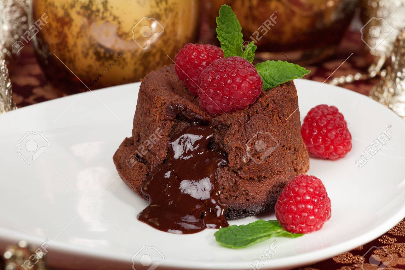 Delicious dark chocolate lava cake dessert served with fresh raspberries and mint Surrounded by Christmas ornaments - 24203683 Delicious dark chocolate lava cake dessert served with fresh raspberries and mint Surrounded by Christmas ornaments - 24203683