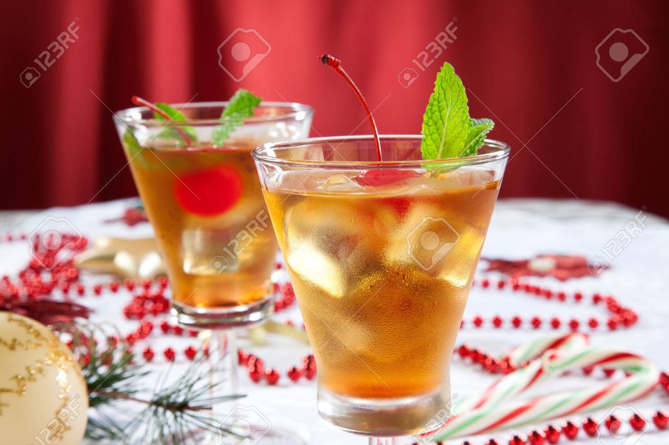 glasses of mint manhattan cocktails surrounded with christmas