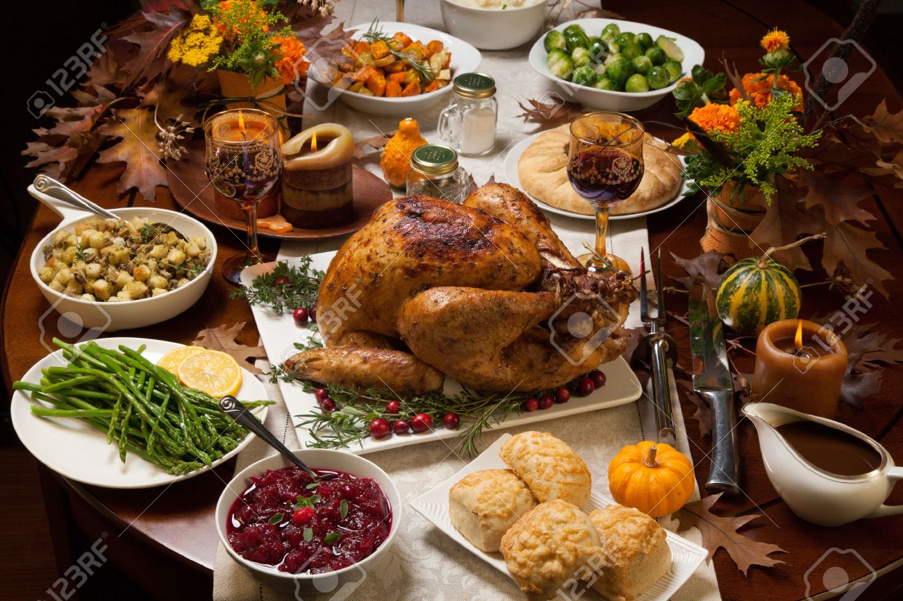 Roasted turkey garnished with cranberries on a rustic style table decoraded with pumpkins, gourds, asparagus, brussel sprouts, baked vegetables, pie, flowers, and candles. - 48015244 Roasted turkey garnished with cranberries on a rustic style table decoraded with pumpkins, gourds, asparagus, brussel sprouts, baked vegetables, pie, flowers, and candles. - 48015244