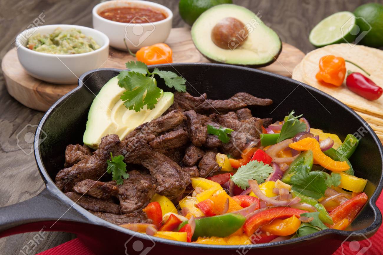 ビーフファヒータ ピーマン タマネギ アボカドの鋳鉄スキレットを用意しています の写真素材 画像素材 Image