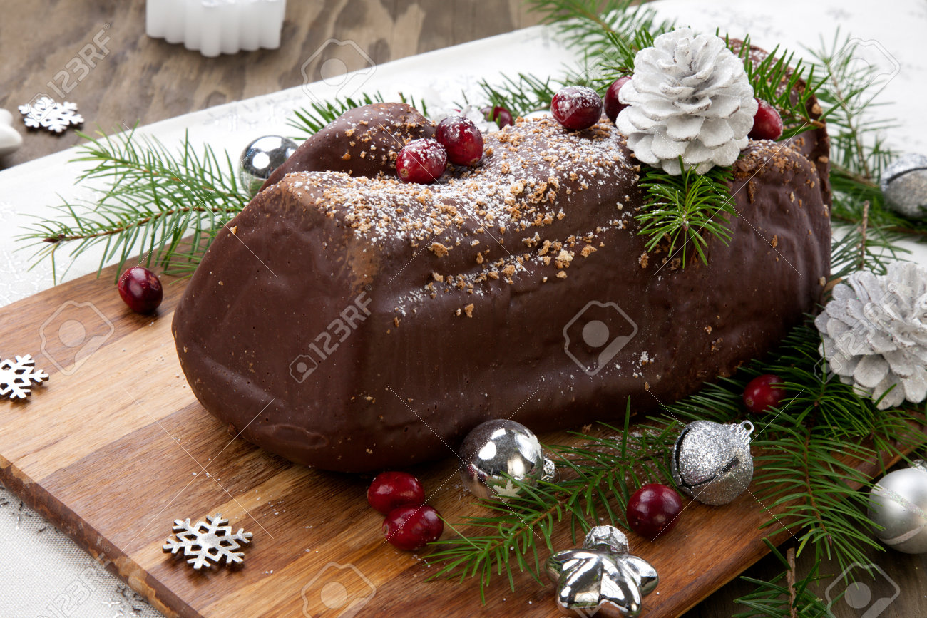 Traditional Christmas chocolate yule log cake with cranberry, Christmas ornamets, and decorations. - 160495923 Traditional Christmas chocolate yule log cake with cranberry, Christmas ornamets, and decorations. - 160495923