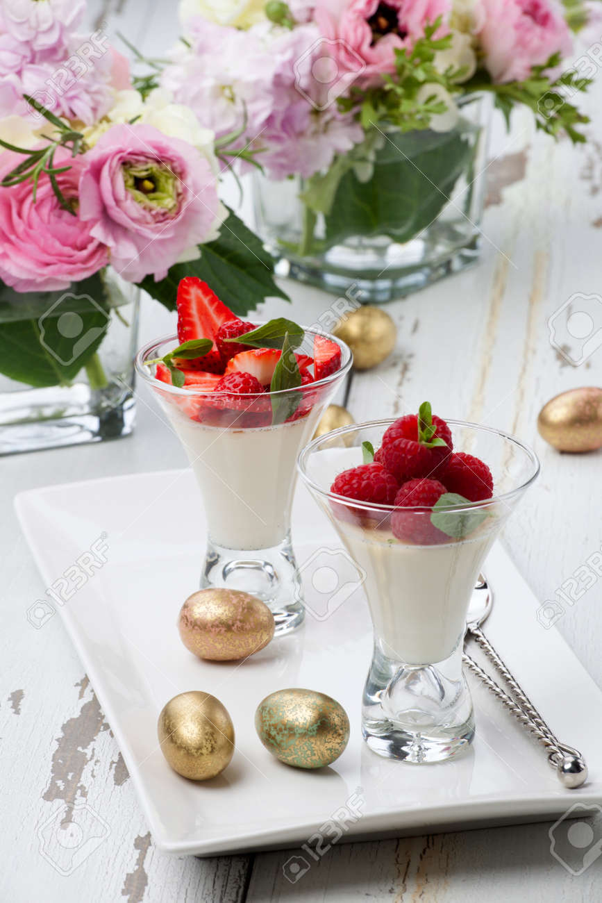 Closeup of Easter Vanilla Panna Cotta Dessert garnished with fresh strawberry and raspberry - 164764443 Closeup of Easter Vanilla Panna Cotta Dessert garnished with fresh strawberry and raspberry - 164764443
